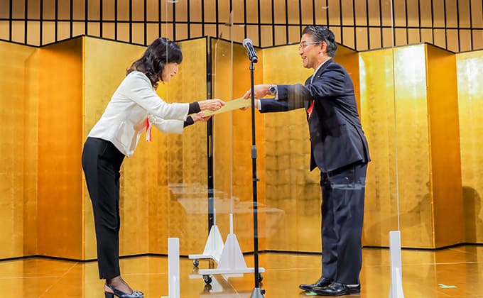 「HRアワード2020」授賞式の様子。選考委員の宮城まり子氏から表彰される取締役HAIQ事業管掌役員 小林孝史さん
